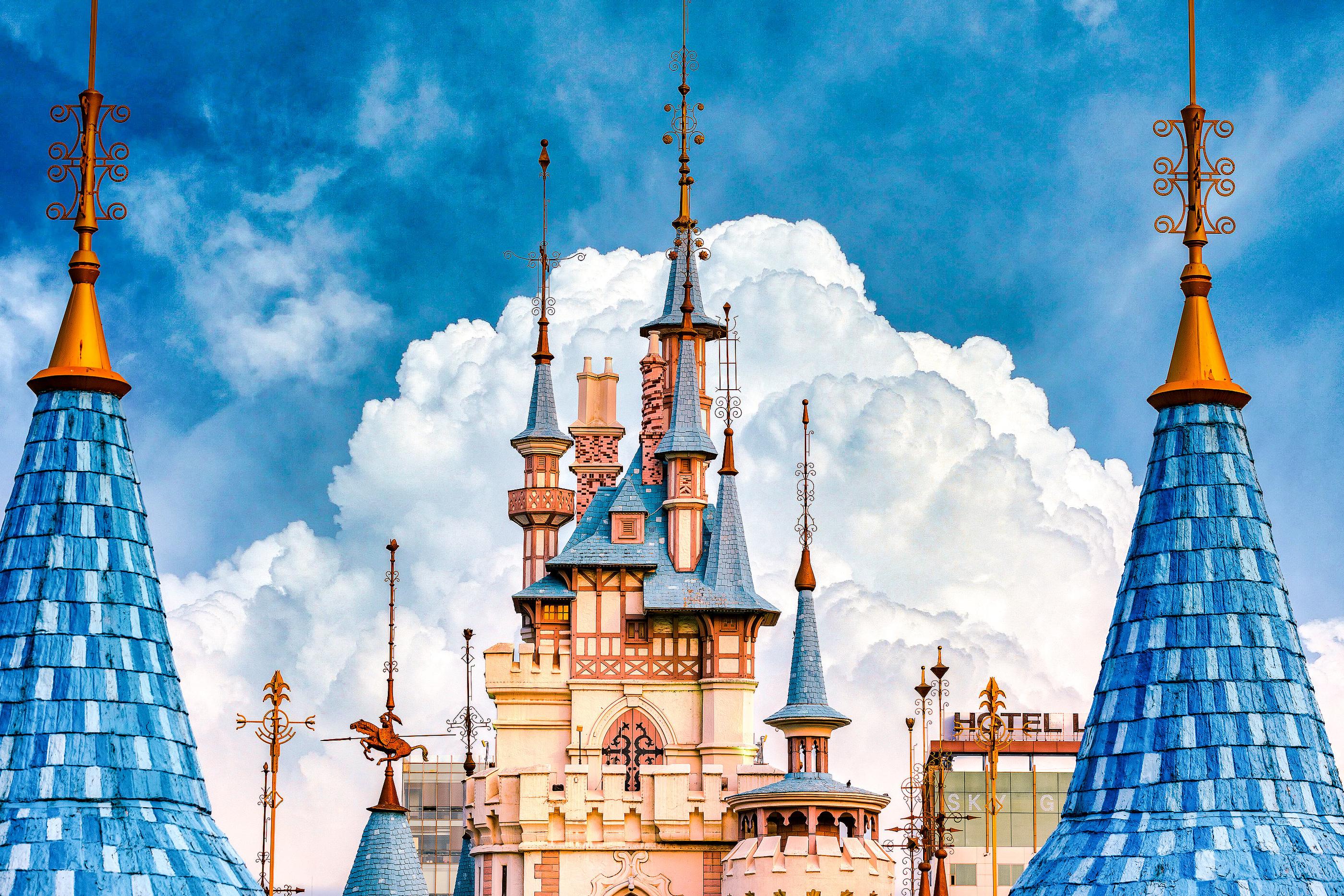 View of Lotte World in Seoul, a famous landmark with blue and white architecture and a towering spire against a cloudy sky.