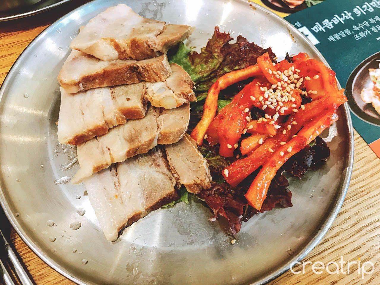 A mouthwatering spread of 육수당 충무로점's 맛보기 수육, seafood, and meat dishes, accompanied by tableware and ingredients.