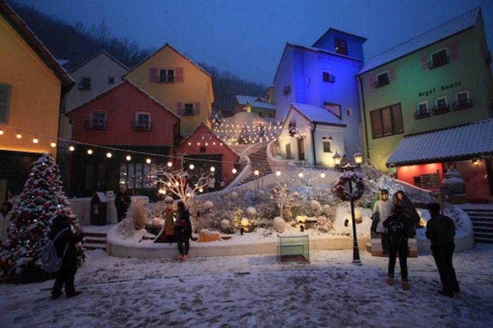 Charming winter neighborhood with European architecture, snow-covered trees and Christmas decorations in Korea's Namiseom Island.