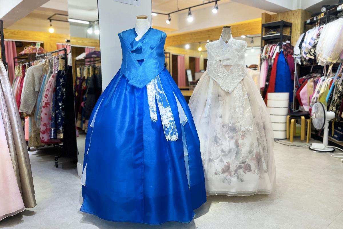 A blue hanbok gown hangs on mannequin at Gyeongbokgung hanbok rental shop for shopping and formal wear.