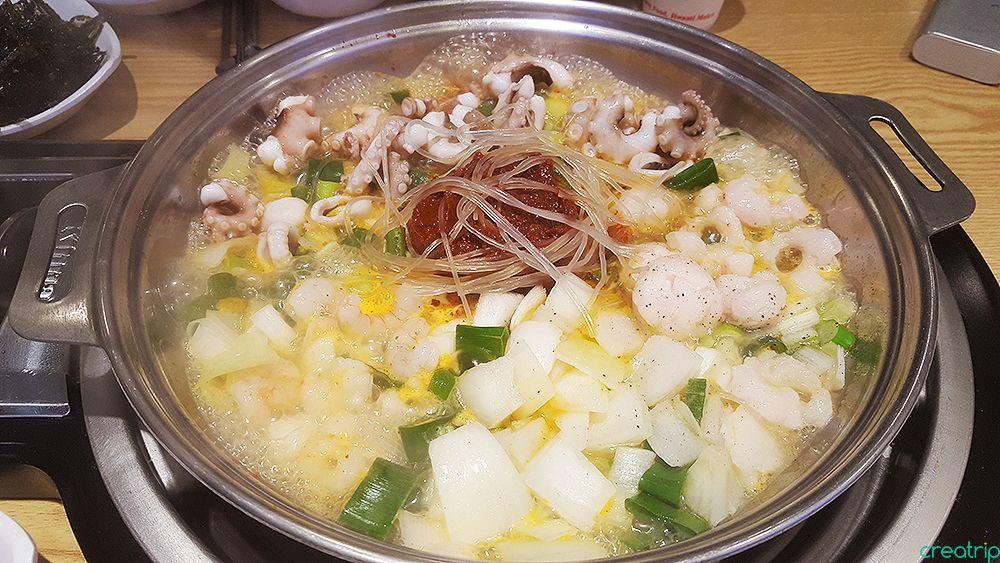 stir-fried squid dish served at Ant House Hongdae with various vegetable ingredients and tableware.