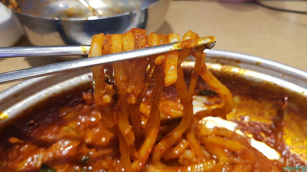 plate of Nakji bokkeum (stir-fried octopus) with side dishes and noddle at Ant House Hongdae. Fast Korean cuisine.