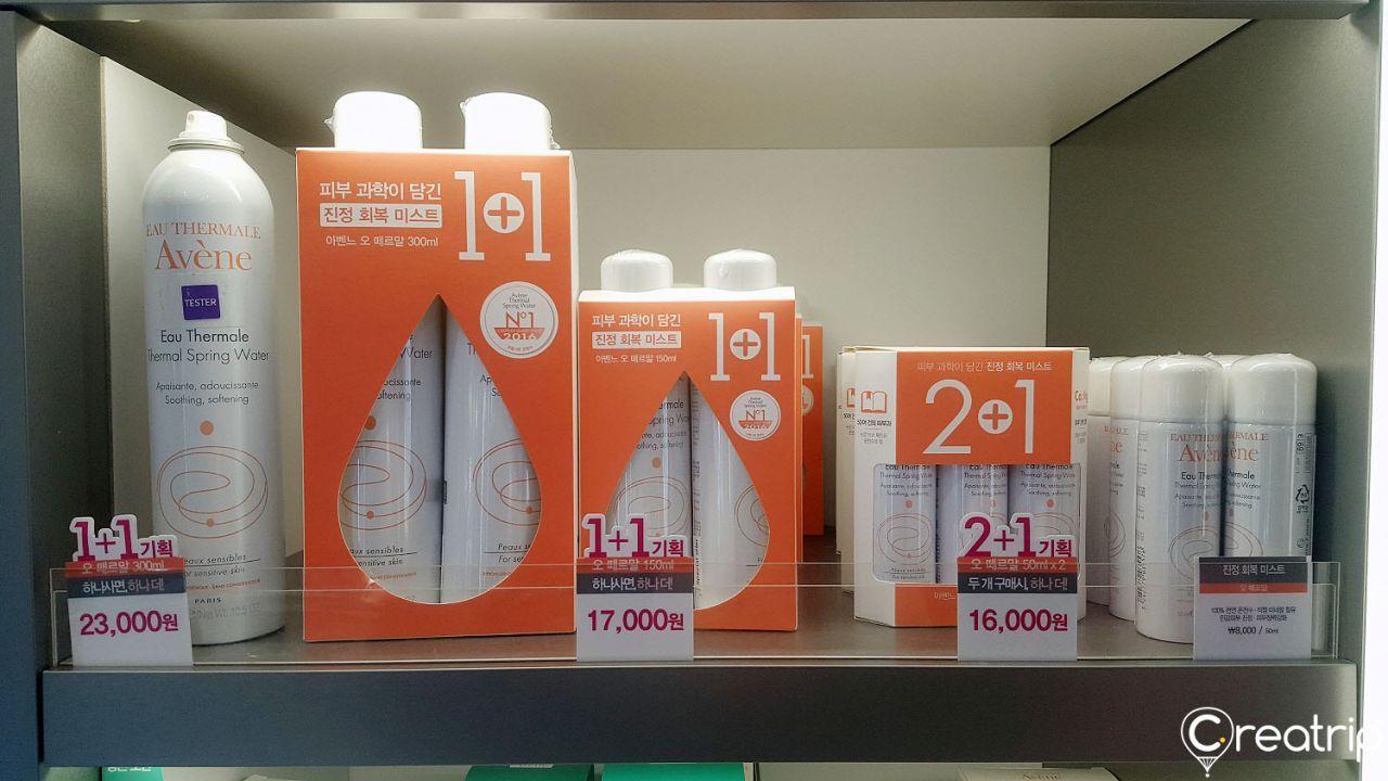 Orange household supplies on shelves at the Olive Young store in Hongdae, including plastic bottles of fluid and gas.