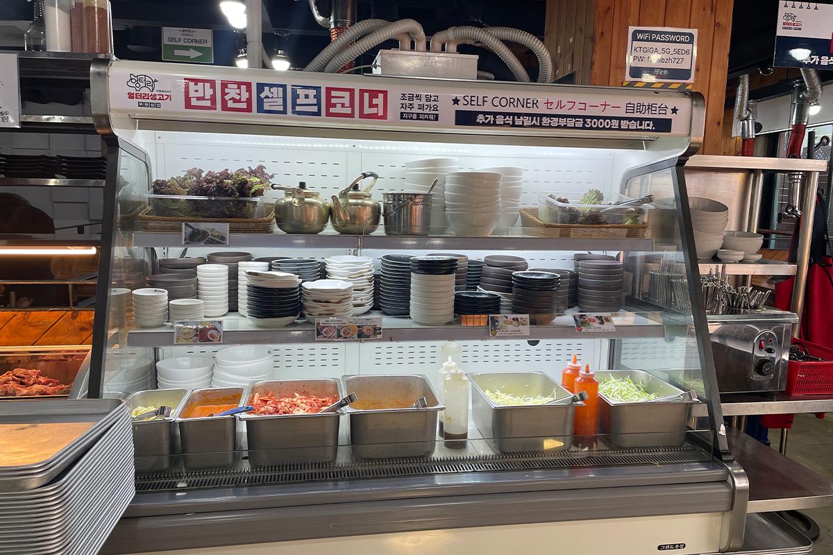Display case filled with home appliances and Korean dishes at 엉터리생고기 명동점.