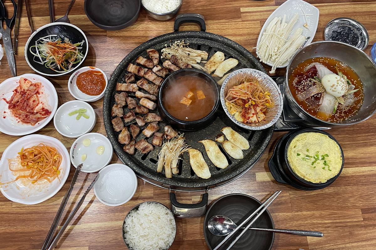 Plate of savory 삼겹살 (pork belly) and side dishes at 엉터리생고기 명동점 restaurant in Korea.