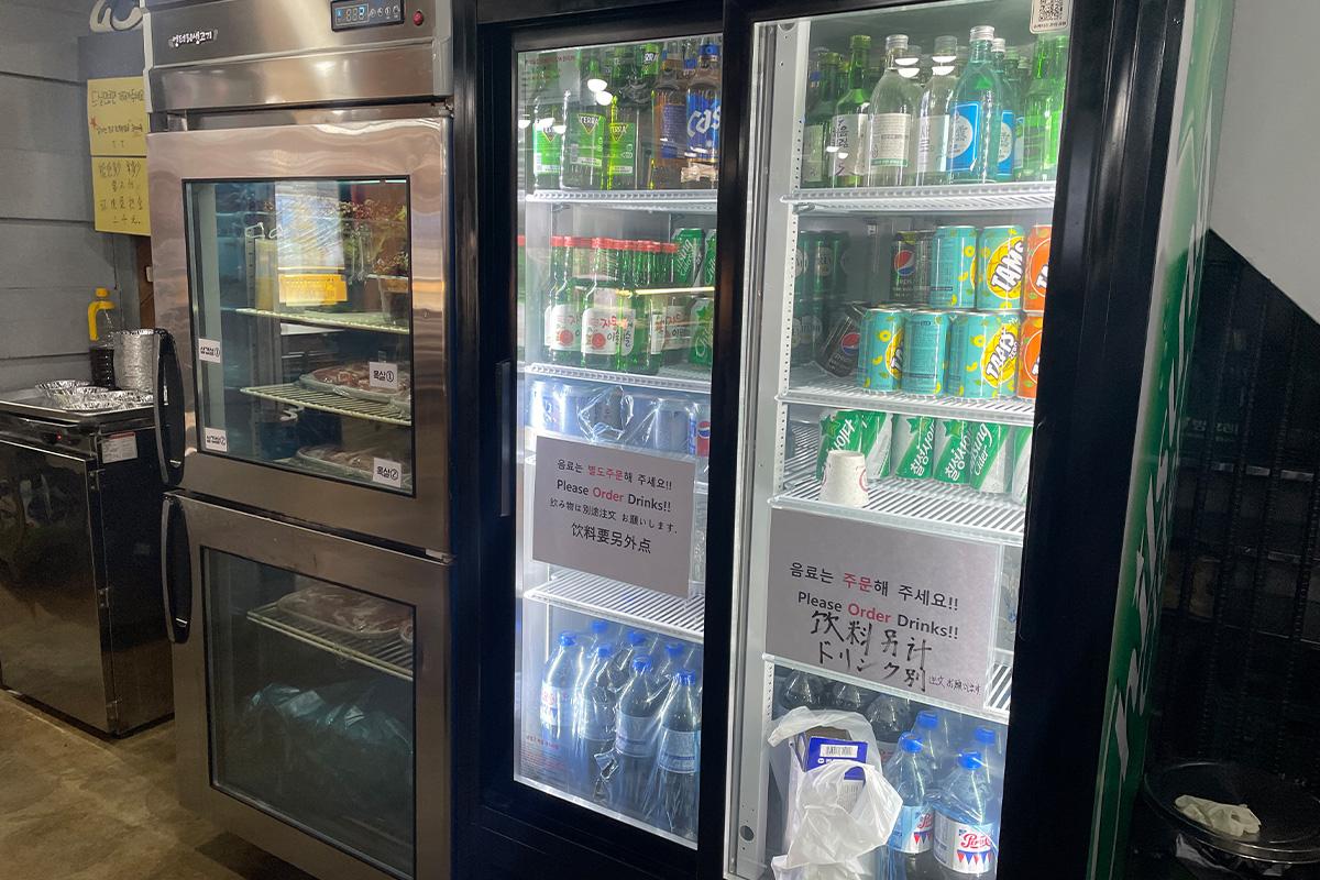 엉터리생고기 명동점 with refrigerators, soft drinks, and glass bottles.