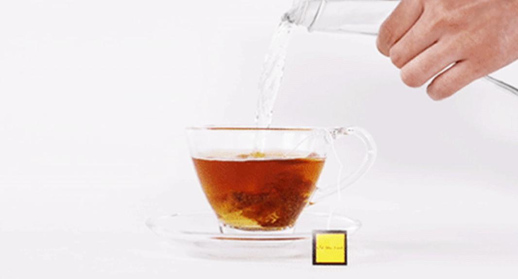 korean brand pin the food magic pumpkin tea bag in clear cup with hand adding water