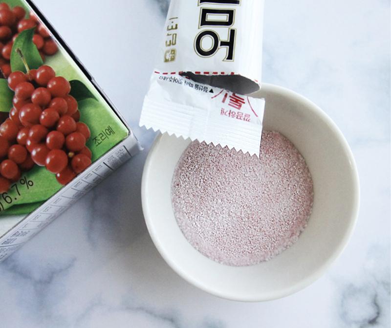 Korean brand damtuh's Omija Plus Tea pouring contents of stick into cup