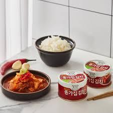 korean brand jongga canned kimchi on counter with a bowl of rice and stew