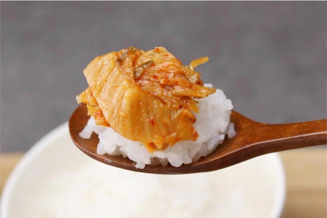 kimchi on a spoon on top of a bed of rice