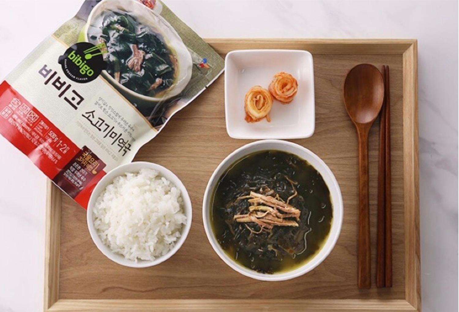 tray of korean brand beef seaweed soup with a side of rice, and kimchi 