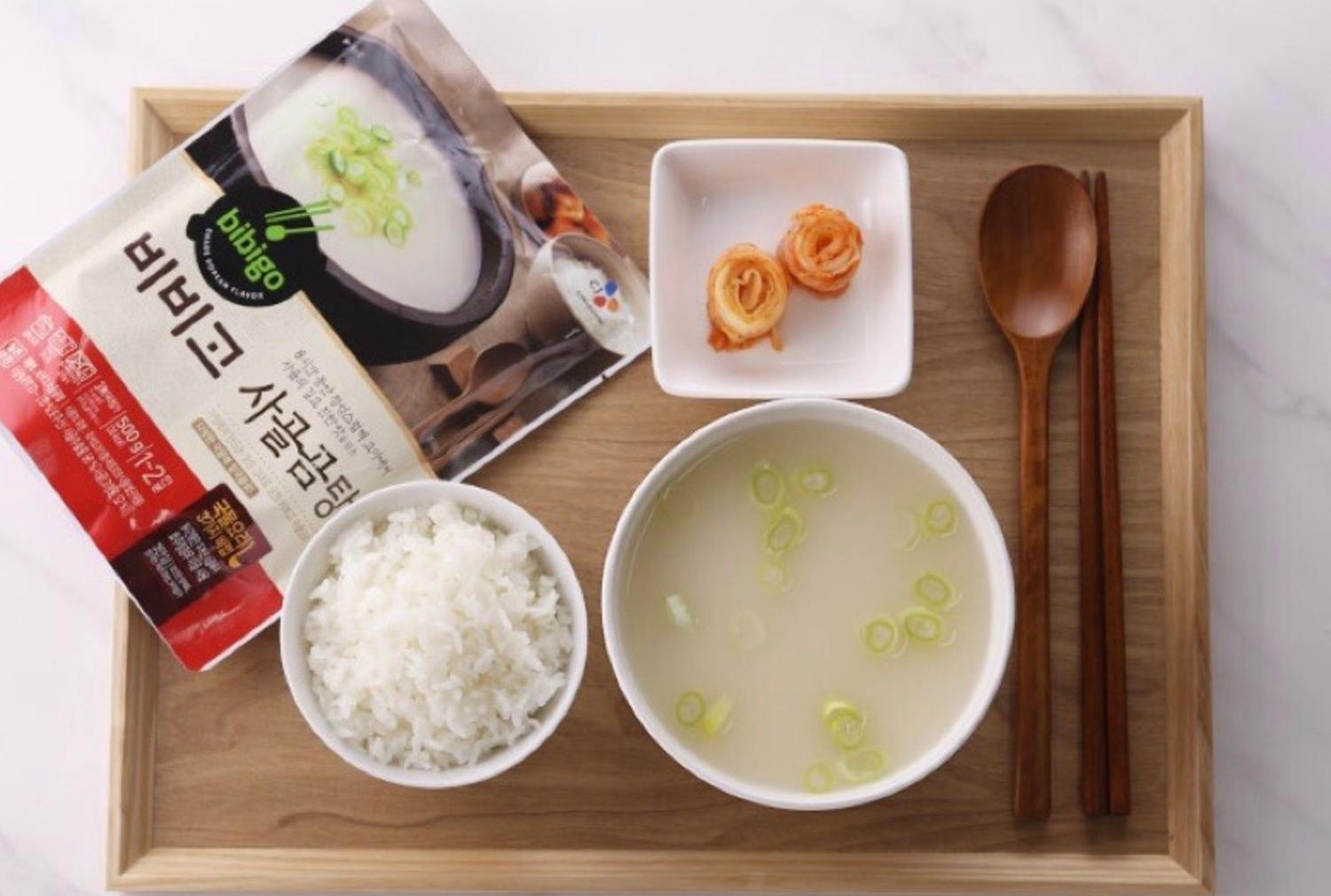 korean brand bibigo's beef bone soup prepared on a tray with rice kimchi and cutlery 
