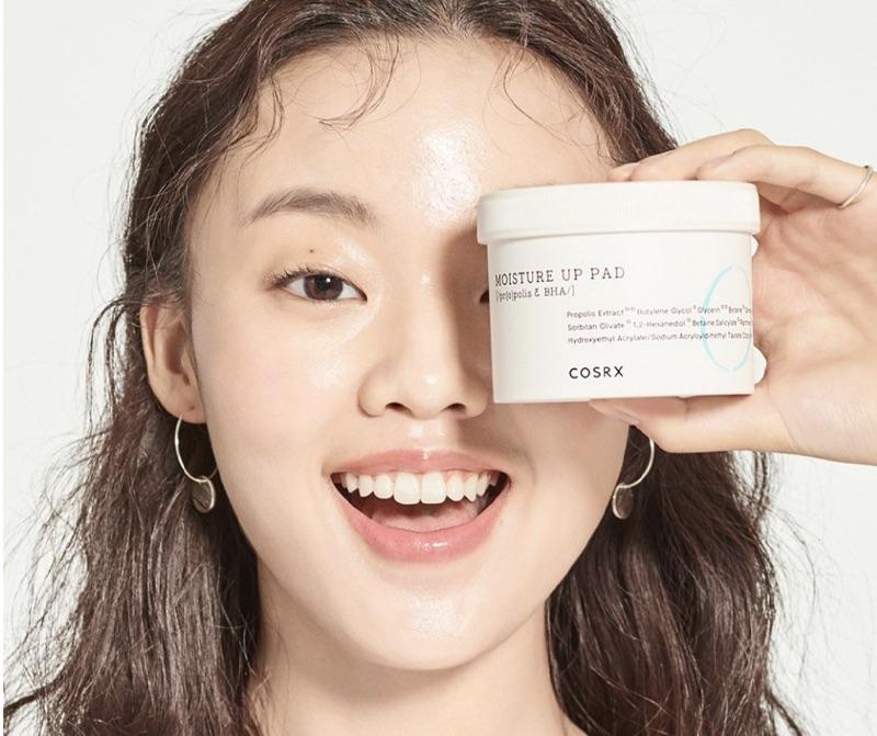 korean brand COSRX one step moisture up pads container held up to model's left eye  