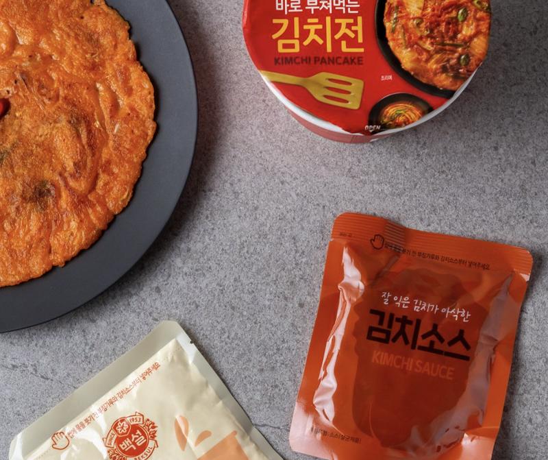 korean brand beksul's kimchi pancake instant cup mix and contents next to plate of kimchi pancake 