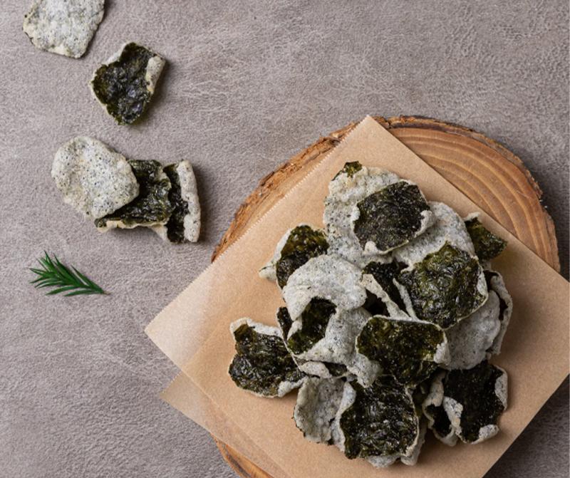 seaweed crisps on wooden plate with parchment paper 