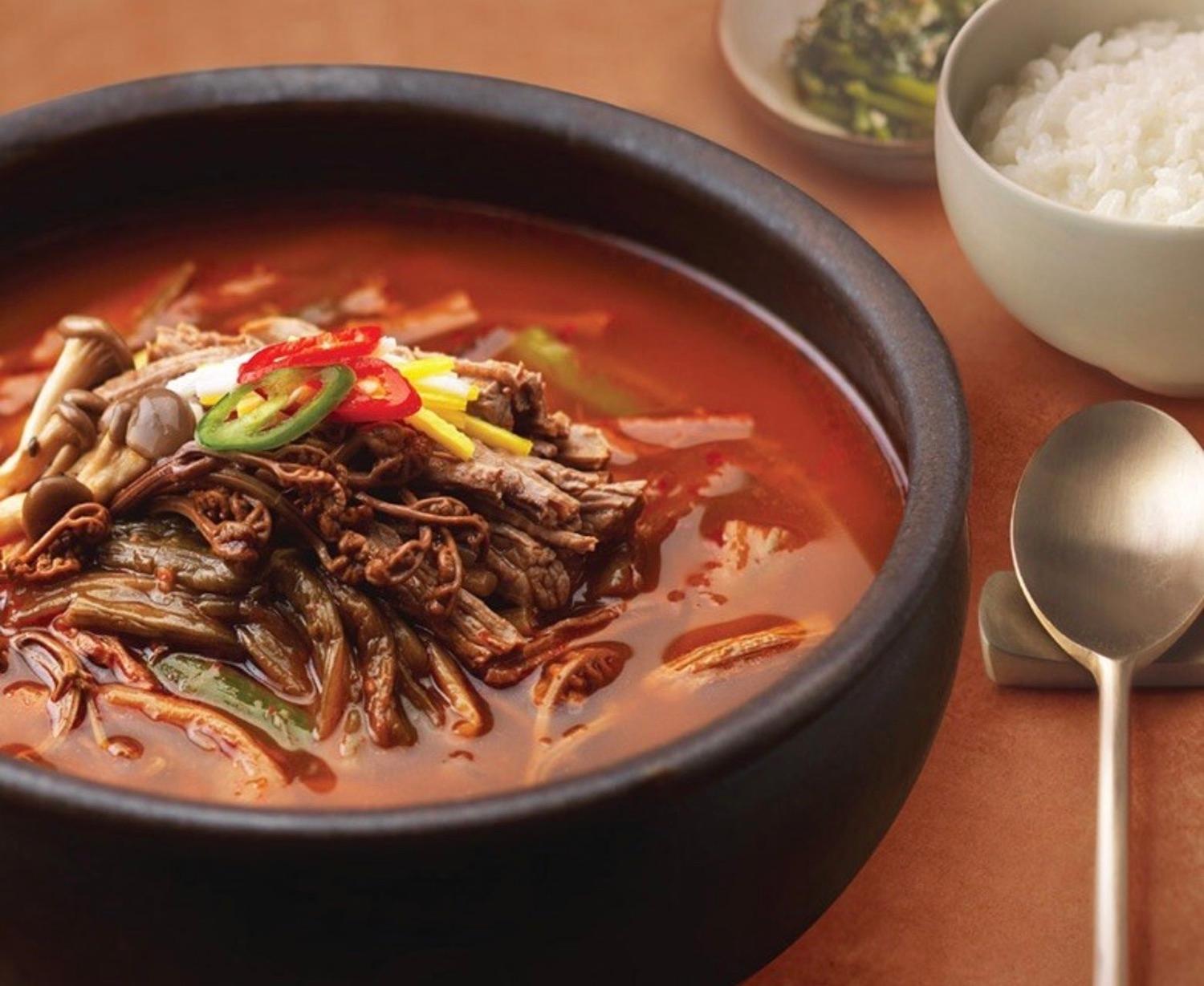 bowl of of korean spicy beef stew (yukgaejang) table setting