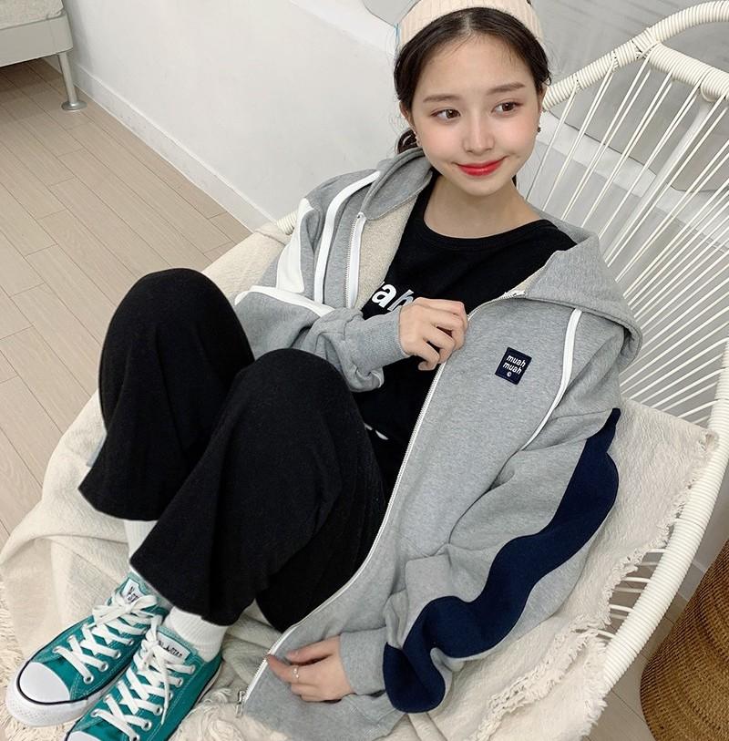 Korean brand muah muah signature combi hood zip up in gray front view worn by model sitting in white chair