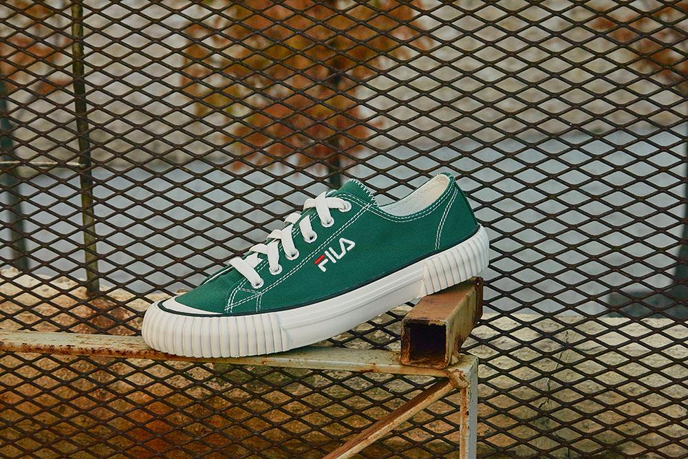 single shoe of Fila korea bumper in green with metal grate background