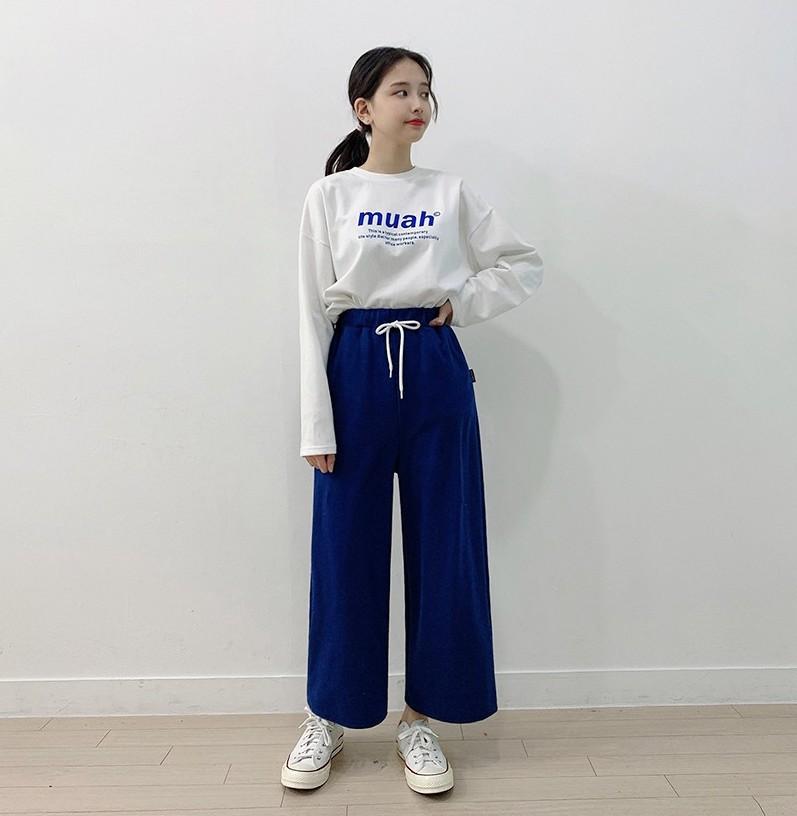 korean brand muah muah signature graphic shirt in white worn with blue pants full model view