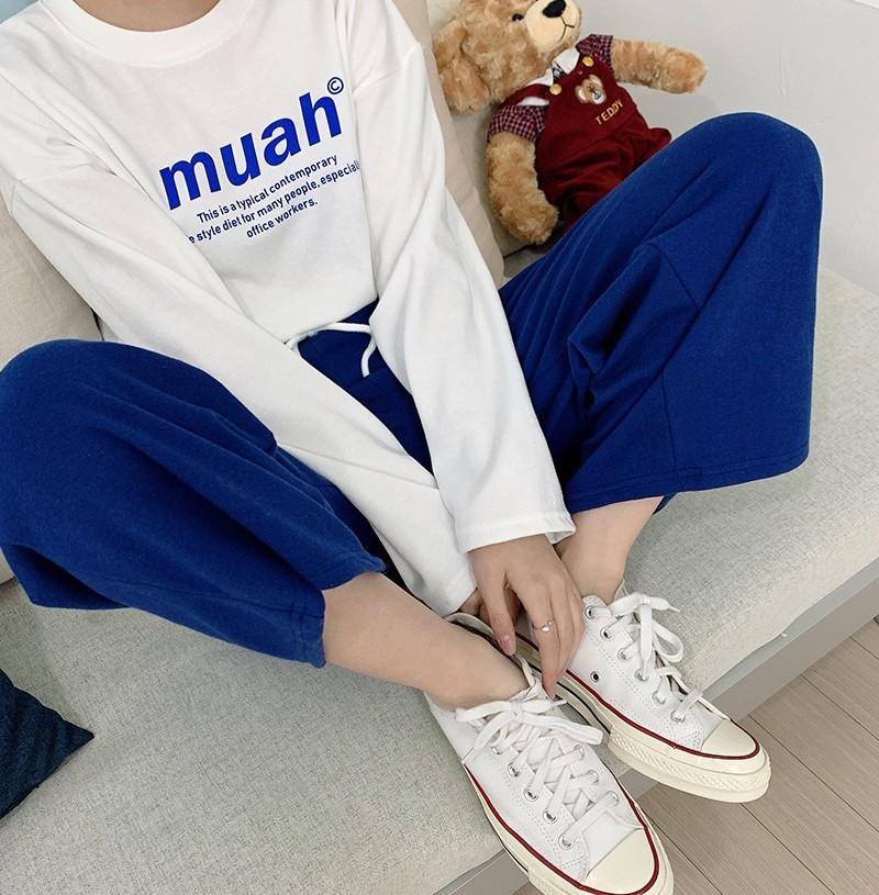 korean brand muah muah signature graphic shirt in white worn with blue pants and white shoes