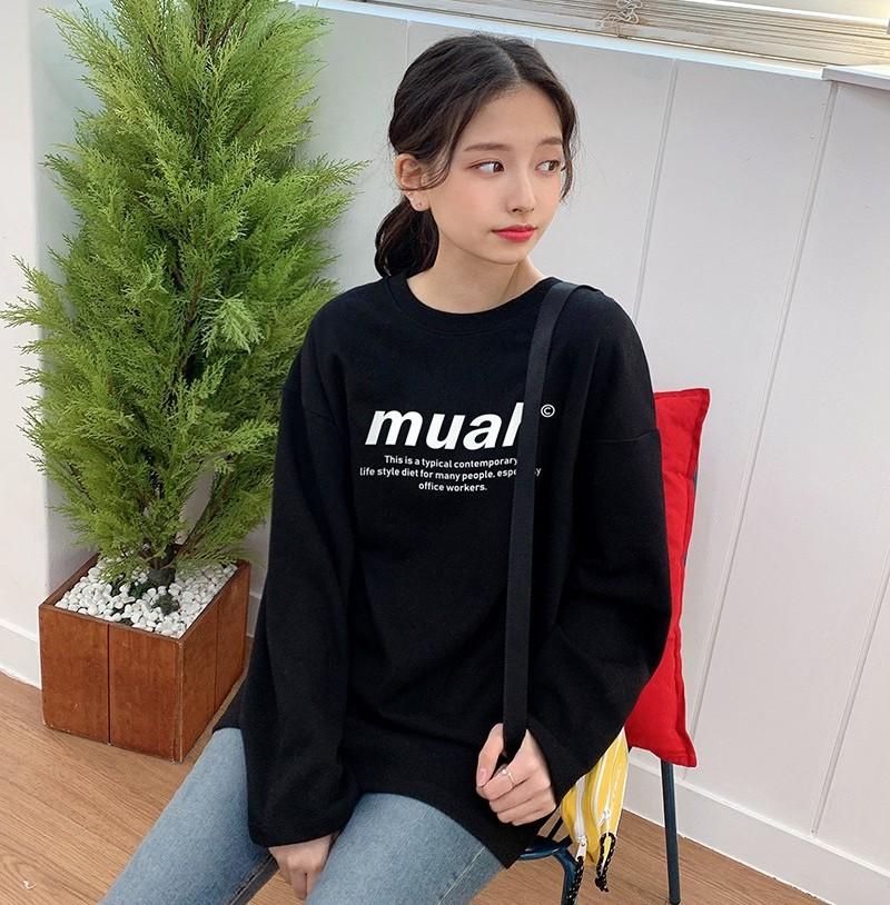 korean brand muah muah Signature Graphic T-Shirt in black worn by model looking to side with yellow bag sitting on chair with red pillow 